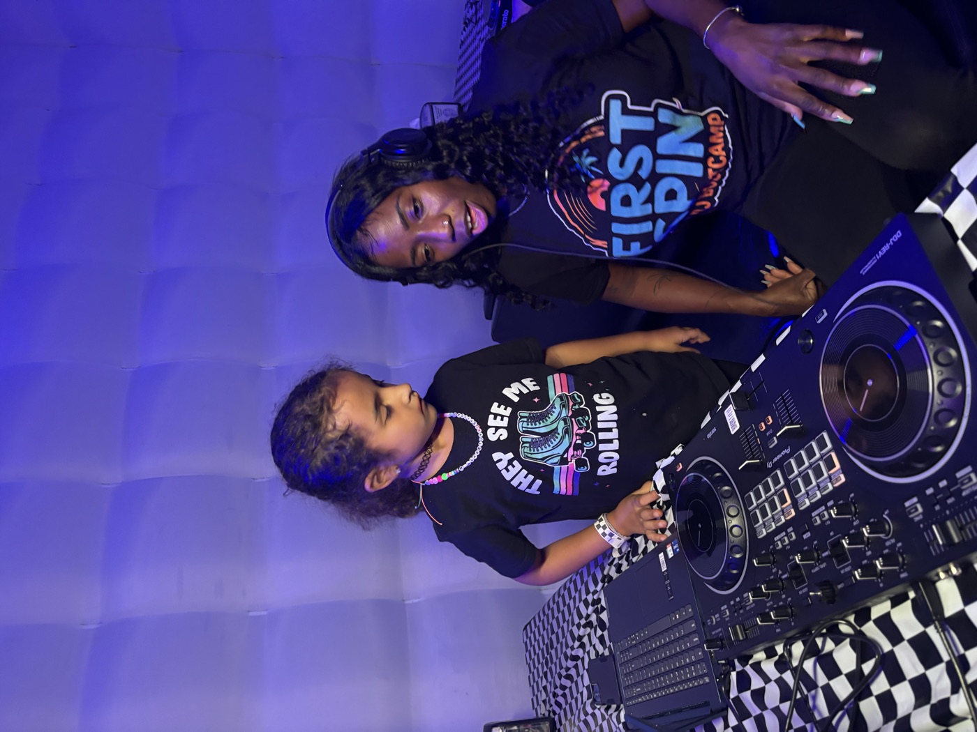A young First Spin student learning to DJ on professional equipment.